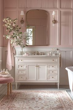 a bathroom with pink walls and white furniture