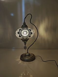 an ornate lamp is lit up on a table with the light turned on and off