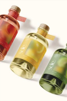 three different colored bottles with labels on them