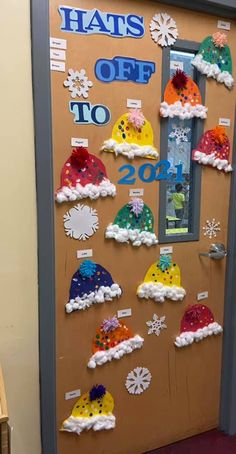 a door decorated with hats and snowflakes for the school's holiday season