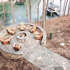 an outdoor fire pit with chairs around it