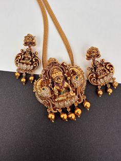 CZ Goddess Lakshmi Nakshi Matte Finish Pendent Set It comes with Complimentary Matte Chain but can be used with any gold chain or beads. Pair it up with Saree or any Indian Attire Pendent Length Approx. 3 Inches Pearl Mala Length : Approx. 16  Inches;  Earring Length : Approx. 2 Inches; Push back. Comes in gift box, Ideal for gifting too. Ready to ship from Boston, MA Delivery time 3-5 days. If you have any questions please let me know. Thank you!! Gold Plated Temple Jewelry Sets, Gold-plated Jewelry For Navratri, Gold Plated Jewelry For Navratri, 22k Gold Temple Jewelry Sets As Gift, Heavy Yellow Gold Temple Jewelry Sets, Gold Plated Temple Jewelry Set For Puja, Heavy Gold Jewelry For Navratri, Gold Temple Jewelry Sets With Tilla, Gold Kundan Jewelry Set With Peacock Design