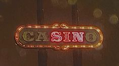 the casino sign is lit up in red and gold