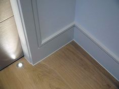 the corner of a room with a light on and a door in front of it