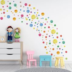 a child's room with colorful polka dot decals on the wall and two children's chairs