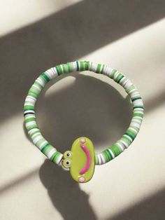 Description Get ready to add some playful charm to your accessories with this Green Smiling Frog bracelet! This shades of Green and White and stretchy beaded bracelet features a center bead in the shape of a happy cartoon frog with surrounding Clay Beads beads. Perfect to add a touch of whimsy to any look! Details fits 7"-7 ½ " wrists green Plastic Smiling Frog: 17.4mm x 24.6mm x 7mm Shades of Green and White Clay Beads Features One of a kind, fashion jewelry, everyday jewelry Great gift for tha Frog Bracelet, Jewelry Everyday, Cartoon Frog, Stretchy Beaded Bracelet, Creative Memories Scrapbooking, Happy Cartoon, Creative Memories, White Clay, Beaded Stretch Bracelet