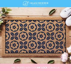 a blue door mat with flowers and shoes on the floor in front of it that says, pre - created with our ink formula