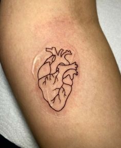 a small heart tattoo on the arm