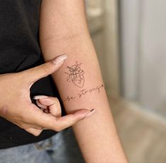 a woman's arm with a small tattoo on it