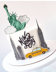 a cake with the statue of liberty on top of it and a taxi in front