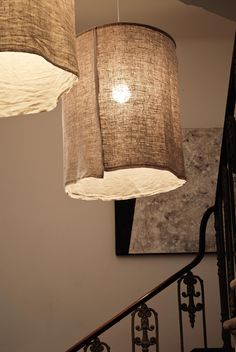 three lamps hanging from the ceiling above a stair case with chandeliers on it