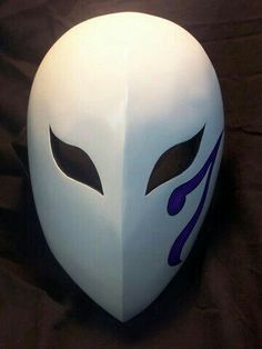 a white mask with purple designs on it