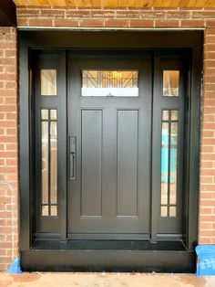 a black front door on a brick building