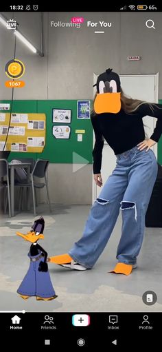 a woman standing next to a cartoon penguin on top of a floor with an orange duck