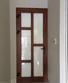 an open door with frosted glass on the inside and outside doors, in front of a white wall