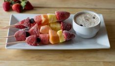 fruit skewers are arranged on a white plate