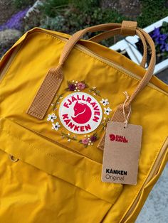 BRAND NEW - READY TO SHIP - Hand Embroidered Fjallraven Classic Kanken Floral Backpack. Color Ochre Yellow. FREE SHIPPING!  (the color from the camera looks off in some pics but the first photo is the closest)  technical details :  height : 36 cm width : 27.5 cm depth : 12 cm volume : 16 I weight : 300 g Everyday Backpack With Embroidered Logo, Embroidery On Kanken, Brown Travel Bag With Embroidered Logo, Rectangular Embroidered Backpack For Travel, Daily Use Backpack With Embroidered Logo, Standard Backpack With Embroidered Logo For Daily Use, Embroidered Rectangular Backpack For Travel, Travel Backpack With Embroidered Logo, Yellow Backpack Aesthetic