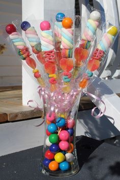 a vase filled with lots of candy on top of a table