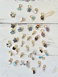 many different colored and shaped charms on a white wooden surface