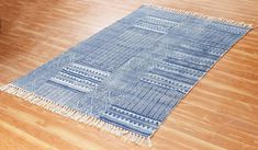 a blue and white rug sitting on top of a hard wood floor