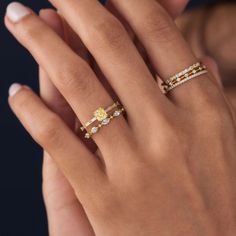 a woman's hand with two rings on her left and one ring on her right