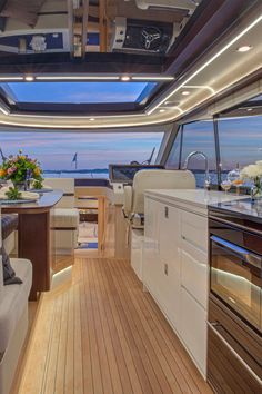 the inside of a boat with wood floors and white furniture on it's sides