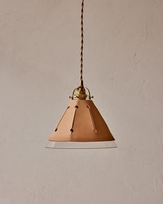 a light hanging from a ceiling with a chain attached to it's end and a white wall in the background