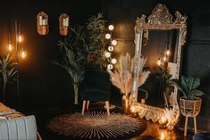 an ornate mirror in the corner of a room with candles and plants on the floor