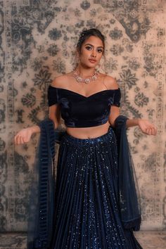 Spice up your style statement with this navy blue coloured lehenga No matter if you want to be a showstopper at any wedding or small ceremony, then this blue coloured lehenga is apt for you. This lehenga is decorated with sequined work and comes along with an off-shoulder velvet blouse. This lehenga is easy to carry so that you can dance around with ease and feel relaxed throughout the ceremony. Due to its appealing design, this lehenga will prove to be a great choice for you without burning a h Navy Blue Colour Lehenga, Lehenga In Blue Colour, Velvet Blouse Designs With Lehnga, Lehenga Blouse Designs Without Dupatta, Blue Velvet Blouse Designs, Velvet Blouse For Lehenga, Velvet Blouse Designs Indian Lehenga Choli, Blouse Designs One Shoulder, Blue Evening Lehenga