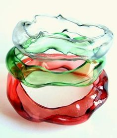 three different colored glass bowls stacked on top of each other in the shape of waves