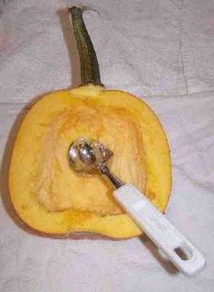 a close up of a knife and some food on a white table cloth with a pumpkin in the background