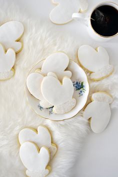 heart shaped cookies on a plate next to a cup of coffee