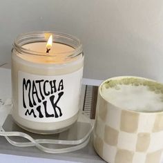 a candle sitting on top of a table next to a tape dispenser