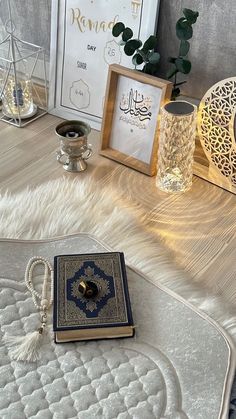 an open book sitting on top of a bed next to candles and other decor items