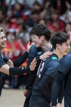 two men are hugging each other in the middle of a team hug at a basketball game