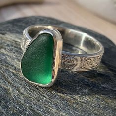 Celtic design sterling silver Cornish sea glass statement ring. The sea glass is a rich green colour, almost velvet in appearance, it sits on a 4 mm wide patterned silver band. The Celtic knot design adds a sympathetic embellishment to the gorgeous green blue sea glass.  Ring size: UK size R.  USA size 9.  Inside diameter 19 mm The sea glass colour is a green blue, this colour glass dates to the late 1800's early 1900's.  The ring is presented in a jewellery box tied with a pretty satin ribbon. Silver Recycled Glass Ring, Handmade Green Rings With Recycled Glass, Elegant Green Sea Glass Jewelry, Silver Celtic Rings, Celtic Ring, Sea Glass Ring, Sea Glass Colors, Celtic Knot Designs, Artisan Rings