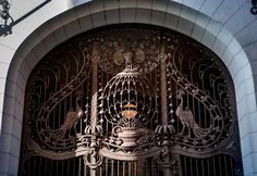 an ornate iron gate on the side of a building