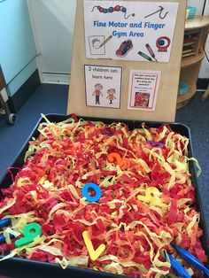 a box filled with lots of different types of yarn and scissors in front of a sign that says fine motor and finger again