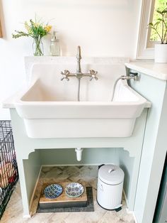 a white sink sitting under a window in a bathroom