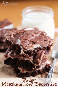 two chocolate brownies with marshmallows on top and a glass of milk