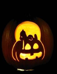 a carved pumpkin with two cats and a dog on it's face in the dark