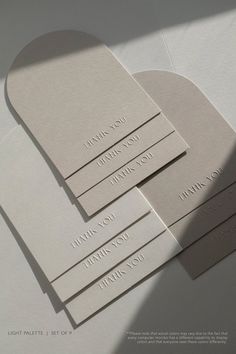 four white business cards with the words thank you written on them, sitting on top of each other