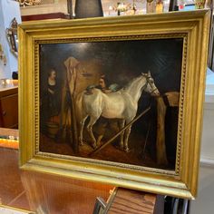 there is a painting on display in the store with people looking at it and a horse standing next to it