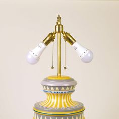 a lamp that is sitting on top of a table next to a vase with two light bulbs