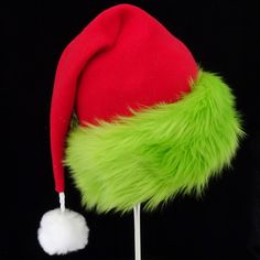 "This festive Santa hat is made up in a red fleece fabric and features an accent brim of lush bright green fur trim, close match to a Grinch green. The red fabric is a soft quality poly fleece fabric, cozy and warm. Proportions of the hat are generous and will fit most head sizes, ladies or gents. The styling is a slouch cone, traditional Santa look. Measurement for opening for your head is 24- 25\" circumference and the length is 20\". There is a white faux fur pompom dangle on the hat." Green Brimmed Winter Costume Hats, Green Winter Costume Hats And Headpieces, Grinch Hat, Kids Santa Hat, Christmas Party Hat, Christmas Party Hats, Green Santa, Red Green Christmas, Green Fur