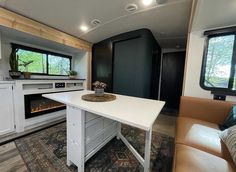 a kitchen area with an oven, stove and couch in the back ground next to a living room