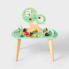 a wooden table with a toy train set on it's legs and a tree