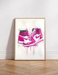 a pink and black nike sneaker shoe with splattered paint on the floor