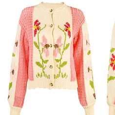 a white sweater with pink flowers and green leaves on the front, is shown in this image