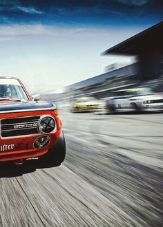 an orange and black truck driving down the road